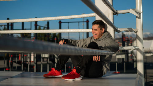 Caucasian male boxer resting in the ring outdoors