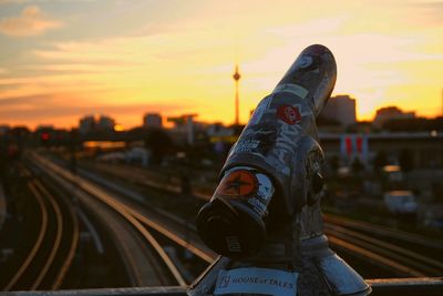 Train by railroad tracks against sky during sunset
