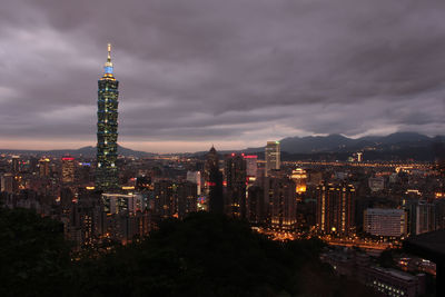 Illuminated cityscape against sky at night