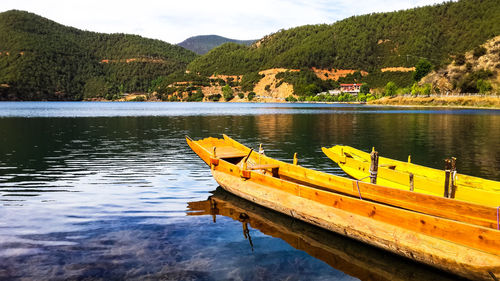 Yellow boat on lake by mountain