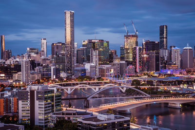 Illuminated buildings in city against sky