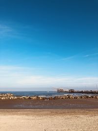 Scenic view of beach against blue sky