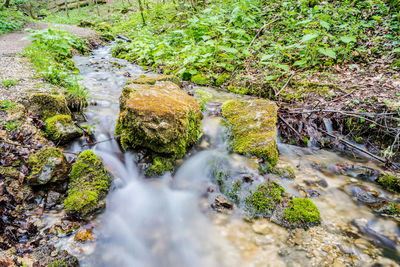 View of stream flowing through rocks