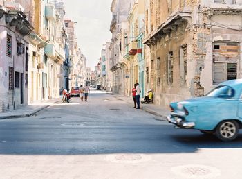 Vehicles on road amidst buildings in city