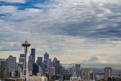 View of cityscape against cloudy sky