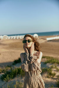 Portrait of young woman sitting at beach