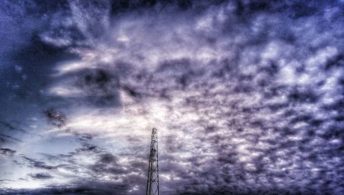 Low angle view of power lines against cloudy sky