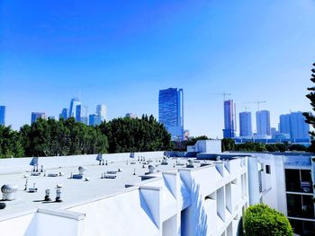 Modern buildings in city against clear blue sky
