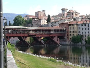 Bridge over river in city against sky