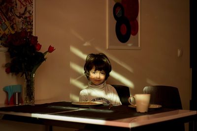 Portrait of boy sitting at dining table