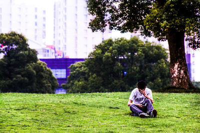 People relaxing on grassy field in park