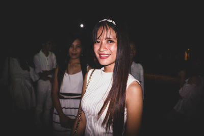 Portrait of a smiling young woman at night