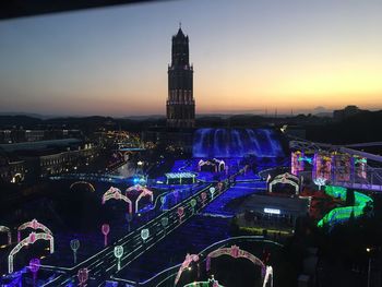 High angle view of city lit up at sunset