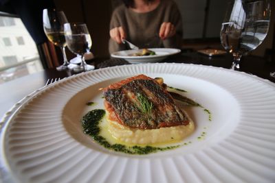 Midsection of mature woman eating food at table