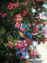 Portrait of smiling young woman against plants