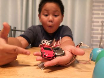 Boy playing with toy on table at home