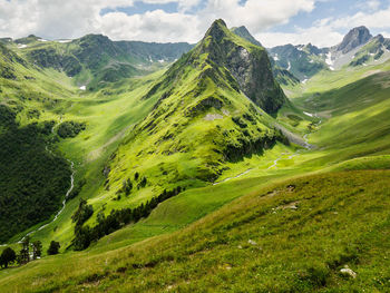 Scenic view of green mountains against sky