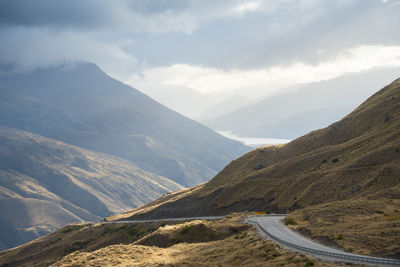 Curvy road leading through mountains pass in alpine environment, new zealand