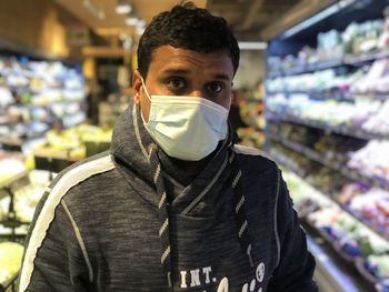 Portrait of young man standing in a store outdoors