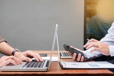 Businessmen discussing over laptops in meeting at office