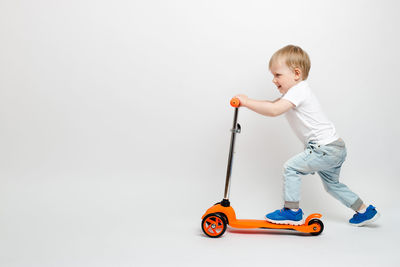 Boy playing with toy against white background