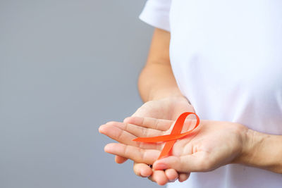 Close-up of woman holding hands over white background