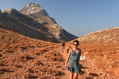 Young woman standing on mountain against clear sky