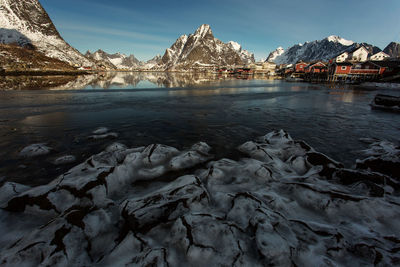 Scenic view of frozen lake against town during winter