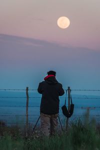 Rear view of man standing in sea against sky