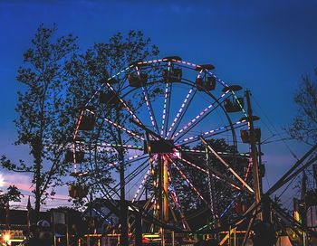 Low angle view of ferris wheel against blue sky