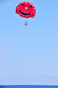 Low angle view of kite flying against clear blue sky