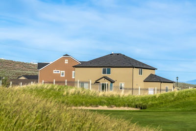 Houses on field against sky