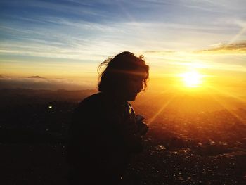 Silhouette of people on landscape at sunset