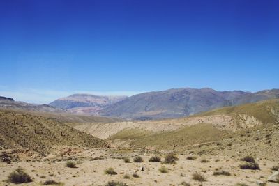 Scenic view of landscape and mountains against clear blue sky