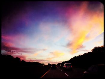 Cars on road at sunset