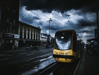 Train on railroad track against cloudy sky