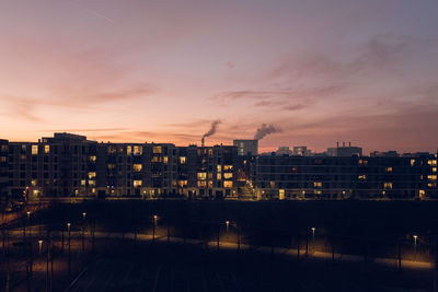 Illuminated buildings against sky at sunset