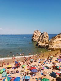 High angle view of people on beach against clear sky