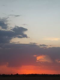 Low angle view of sky over silhouette field during sunset