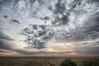 Scenic view of field against sky at sunset