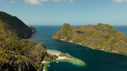 Tropical lagoon with sandy beach surrounded by cliffs, aerial view. el nido, philippines, palawan. 