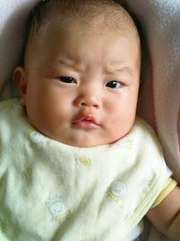 Portrait of cute baby lying on bed