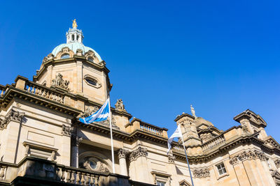 Low angle view of bank of scotland against clear blue sky