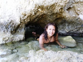 Portrait of smiling young woman on rock