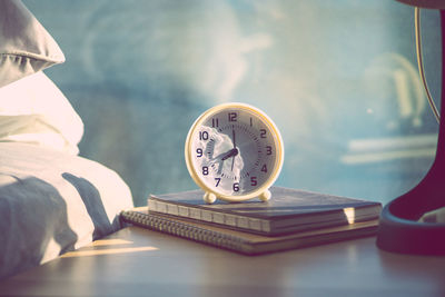 Close-up of books and alarm clocks on table