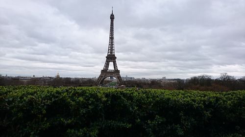 View of tower in field against cloudy sky