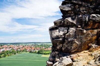 Built structure on landscape against cloudy sky