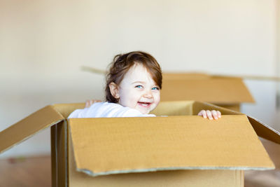 Portrait of cute girl with blue eyes in cardboard box