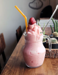 Strawberry smoothie or milkshake in jar on black rustic background, healthy food