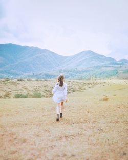 Rear view of woman standing on land